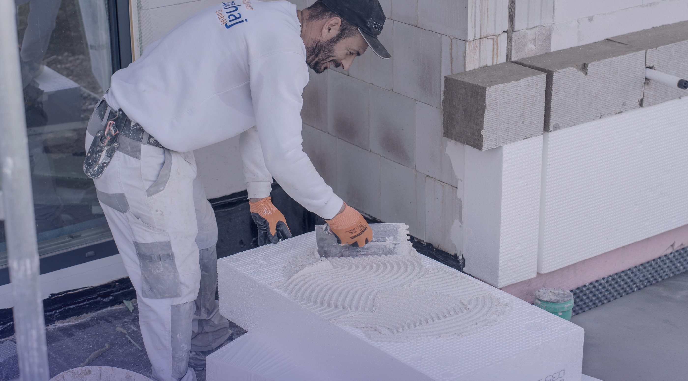 Stuckateur der Xhoxhaj Gruppe beim Verputzen einer Wand
